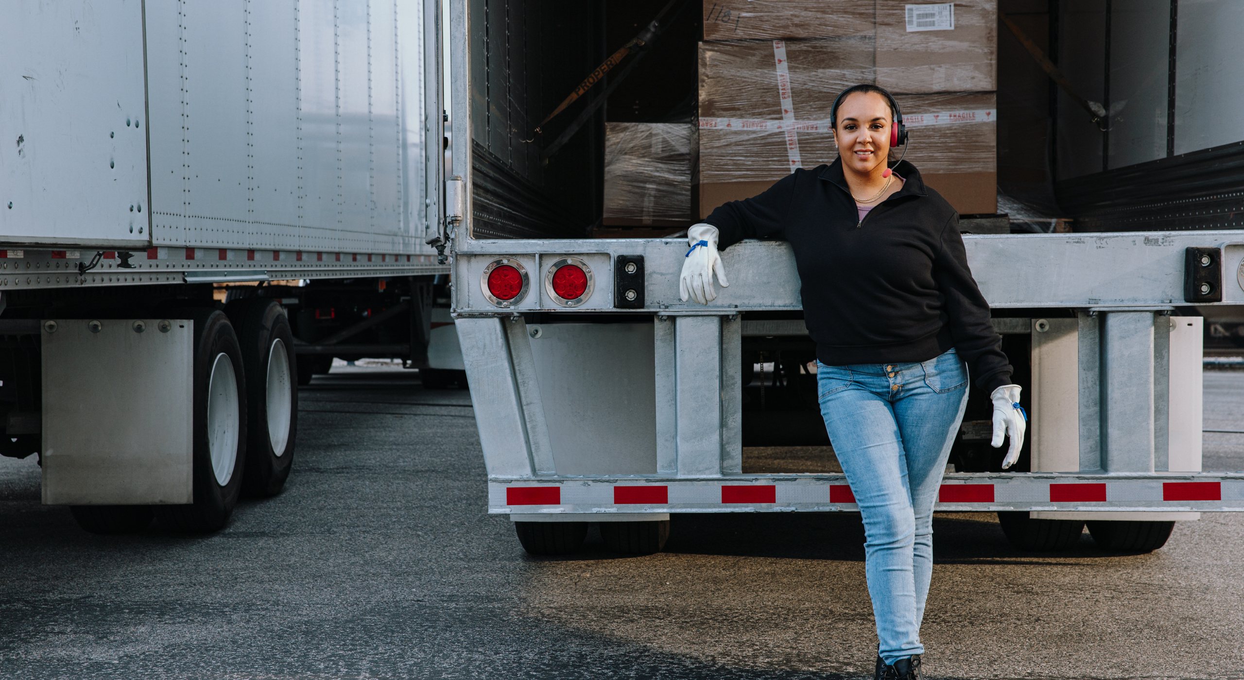 Uber Freight and Hart Print Driver standing behind loaded semi truck with door open