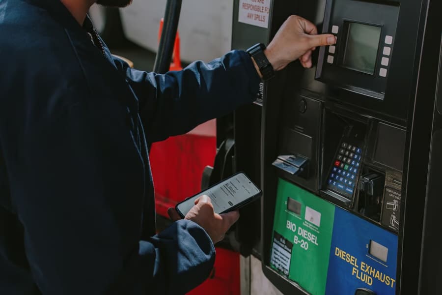Finance Hub Driver using Uber Freight carrier card and looking at the carrier app at the fuel pump